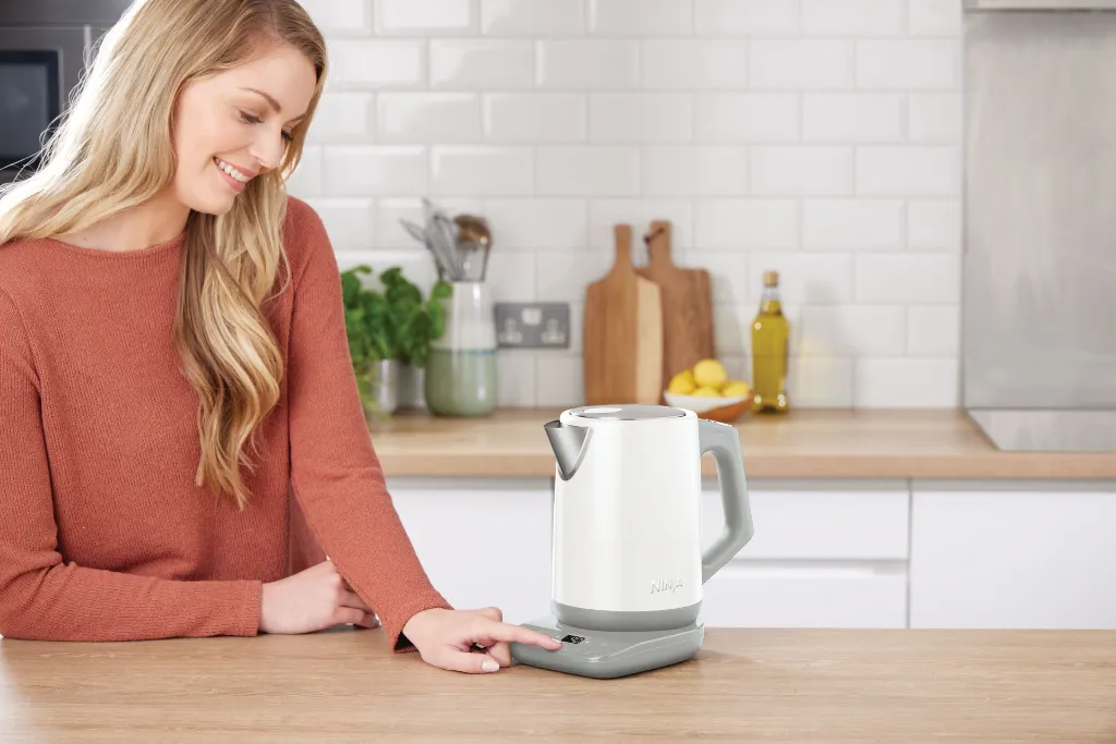 JPG-KT200EUWH_White Kettle_InUse_Pressing UI_Woman_Wide_6_rt.webp