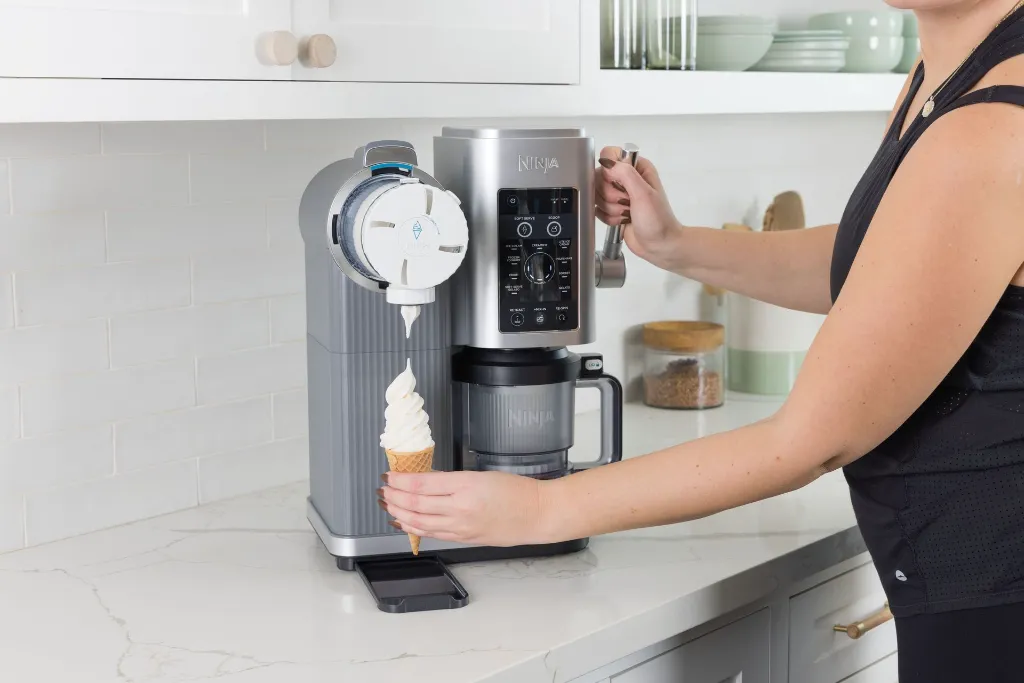 JPG-R_NC701EU_InUse_Kitchen_OnCounter_Dispensing_Woman3.webp